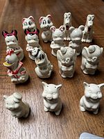Group of 15 vintage Disney ceramic salt and pepper shakers on a wood table showing wear and finish loss.