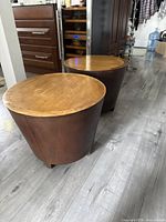 Two round tapered side tables positioned together on floor