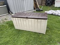 Front view of the deck box showing beige body and brown lid with latch