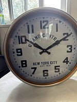 Front view of Grand Central wall clock showing dial with large black numbers, black hands, and NYC text