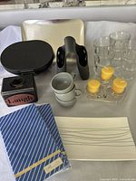 Photo showing all kitchen items including trays, glasses, candle holders, cups, and serviettes arranged on table