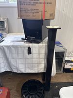 Full view showing the mailbox, post, and round mounting base on the table with the mailbox box on top.