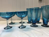 Set of 4 margarita and 4 beer glasses in Mexican blue blown glass showing shape and color.