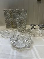 Set of six items: one lead crystal vase, three bowls, two candle holders, and a decorative box, displayed on a white cloth.