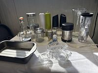 Wide shot showing entire lot including kitchenware, glassware, and cups