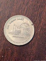 Reverse side showing 'Jeux Canada Games', 1975, sportsplex building with flags, and 'SPORTSPEX' text with wear and dark spots.