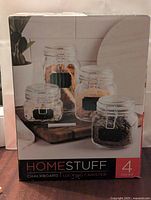 Box front showing 4-piece set of HomeStuff chalkboard locking canisters with chalk marker and images of jars containing dry goods.