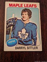 Front of the hockey card showing Darryl Sittler in Toronto Maple Leafs uniform, holding a Louisville hockey stick.