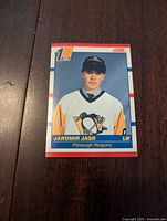 Front of Jaromir Jagr rookie card in Pittsburgh Penguins uniform, showing draft first round logo and player image.