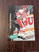 Front side of Nicklas Lidstrom rookie card showing player in Detroit Red Wings uniform during a game.