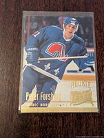 Front of 1994-95 Fleer NHL Peter Forsberg rookie card in protective sleeve featuring player in Quebec Nordiques blue jersey.