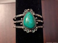 Front view of the sterling silver Navajo style cuff with green turquoise stone showing the pear-shaped cabochon and silver bead decorative work
