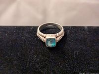 Front view of the women's sterling silver amazonite ring on a black background, showing the square amazonite gemstone and the twisted rope band detail.