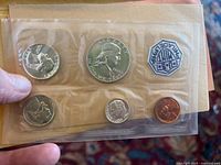 Photo showing the obverse of the 1963 coins in original sealed plastic with Franklin half dollar prominently visible.