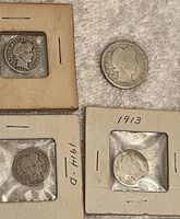 Coins including Barber quarters dated 1907, 1911-D, 1913 in cardboard holders and loose, showing front obverse with Barber head profile