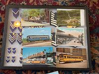 Top view of a page containing eight color postcards mainly featuring buses, train platforms, and scenic transport views.
