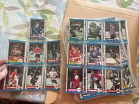 Two photos showing pages of hockey cards in protective sleeves inside a binder.