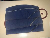 Photo of one blue Vietnam era USAF garrison cap lying flat displaying silver piping detail along seams and leather banding inside