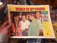 Lobby card for 'World In My Corner' featuring Audie Murphy in a boxing robe with other characters and a referee