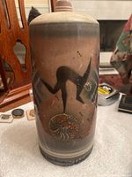 Full front view of the tall ceramic bottle showing raku glaze and black silhouette figure art deco design.