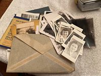 The lot shown with various scattered black and white photographs, small portrait photos, negatives, and aged paper materials.