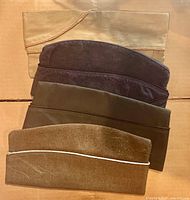 Four garrison caps laid flat to show style and condition from top view