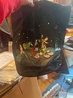 Front view of black laundry bag showing Marvin the Martian and Pluto cartoon characters surrounded by stars and space-themed elements, held open to display design and condition.