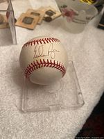 Nolan Ryan signature on the baseball shown clearly on white surface.