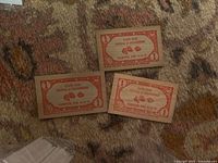 Front side of three wooden nickels showing festival name, date and denomination