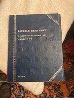 Closed blue coin collection book with gold embossed text: "LINCOLN HEAD CENT COLLECTION STARTING 1941 NUMBER TWO No. 9030"