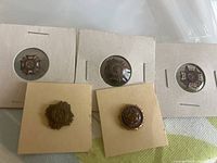 Six VFW lapel pins arranged on a surface with some on individual square card holders, showing different designs and backing types.