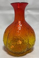 Front view of the 1970's Blenko glass vase, showing the bulbous textured body with red-to-yellow gradient.