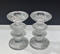 Front view of both clear textured glass Iittala Icicle candlesticks with original stickers