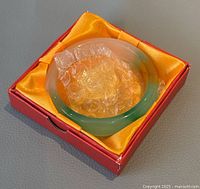 Natural jade d-shaped bangle displayed inside original red box lined with yellow satin and protective bubble wrap