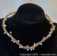 Front view of the vintage silver necklace with evenly spaced small white freshwater pearls on a black display bust.