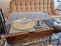 Overall view of KLH Model 20 turntable with clear dust cover, showing wood grain base and control panel.