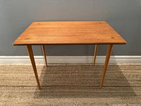 Full view of teak side table showing rectangular top and tapered legs.