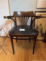 Front view of the bentwood chair with curved backrest, armrests, and black seat cushion.
