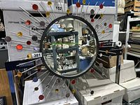 Full front view of the multicolor sunburst wall mirror showing circular colored accents and radial metal rods around the mirror.