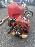 Close-up of the RedMax CZ23N gas string trimmer engine and gas cap, showing wear and dirt.