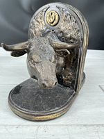 Bull head bookend showing detailed sculpting of bull's face and horns, bronze and gold-tone finish