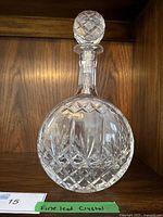 Full view of the lead crystal decanter with stopper showing rounded shape and intricate cut glass pattern.