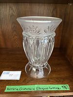 Front view of a clear crystal glass hurricane candle holder with detailed cut patterns and frosted top rim.