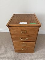 Front view of the wooden 2-drawer filing cabinet showing brass handles and label holders