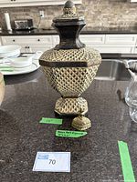 Decorative jar with lid, showing full item and dimensions in background