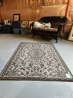 Full view of the outdoor rug laid flat on a floor showing the entire floral pattern and shape
