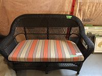 Front view of rattan wicker loveseat with striped cushion