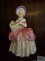 Front and side view of the Royal Doulton 'Cissie' figurine showing the detailed coloring and sculpting in porcelain.