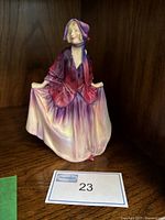Front view of Royal Doulton Sweet Anne porcelain figurine in purple and pink dress.