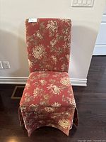 Front view of the upholstered accent chair showing its floral fabric and high backrest.